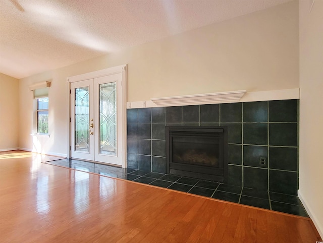 3904 Williamson Cir, Myrtle Beach, SC 29579 - unfurnished living room featuring french doors, wood finished floors, a fireplace, a textured ceiling, and baseboards