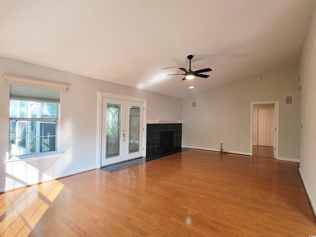 3904 Williamson Cir, Myrtle Beach, SC 29579 - unfurnished living room with wood finished floors, ceiling fan, vaulted ceiling, baseboards, and a tile fireplace