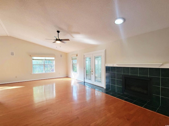 3904 Williamson Cir, Myrtle Beach, SC 29579 - unfurnished living room featuring wood finished floors, vaulted ceiling, a ceiling fan, a textured ceiling, and a fireplace