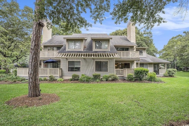 213 Westleton Dr Unit 16B, Myrtle Beach, SC 29572 - back of house featuring a chimney, a yard, a balcony, and roof with shingles