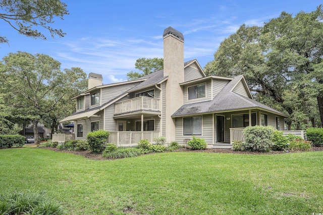 213 Westleton Dr Unit 16B, Myrtle Beach, SC 29572 - back of house with a chimney, a balcony, a yard, and roof with shingles