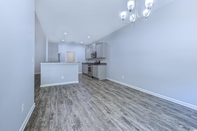 617 Chiswick Dr, Conway, SC 29526 - unfurnished living room featuring baseboards, wood finished floors, a chandelier, and a sink