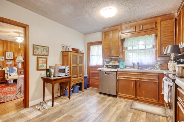 2004 Seitter St, Georgetown, SC 29440 - kitchen with appliances with stainless steel finishes, a textured ceiling, light wood-type flooring, light countertops, and brown cabinetry