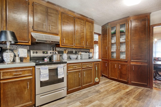 2004 Seitter St, Georgetown, SC 29440 - kitchen featuring stainless steel range with electric cooktop, under cabinet range hood, light countertops, decorative backsplash, and a textured ceiling