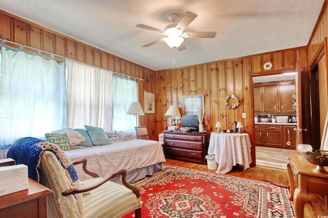 2004 Seitter St, Georgetown, SC 29440 - bedroom with light wood-type flooring, wood walls, a textured ceiling, and ceiling fan