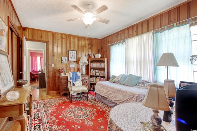 2004 Seitter St, Georgetown, SC 29440 - bedroom featuring wood finished floors, wood walls, a textured ceiling, a ceiling fan, and ornamental molding