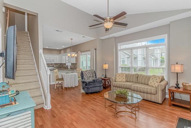 503 20th Ave N Unit 15B, North Myrtle Beach, SC 29582 - living room with light wood-style flooring, a ceiling fan, a chandelier, vaulted ceiling, and stairway