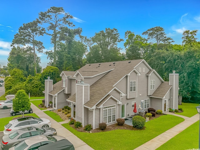 503 20th Ave N Unit 15B, North Myrtle Beach, SC 29582 - view of front of house featuring roof with shingles, a chimney, and a front yard