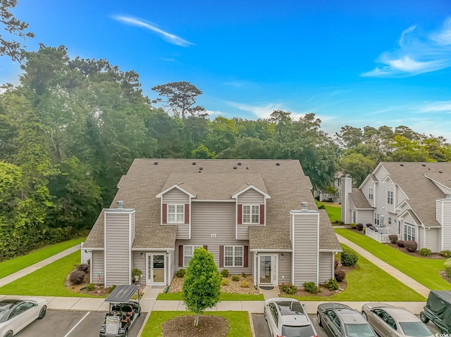 503 20th Ave N Unit 15B, North Myrtle Beach, SC 29582 - view of front facade with uncovered parking, a chimney, roof with shingles, and a front lawn