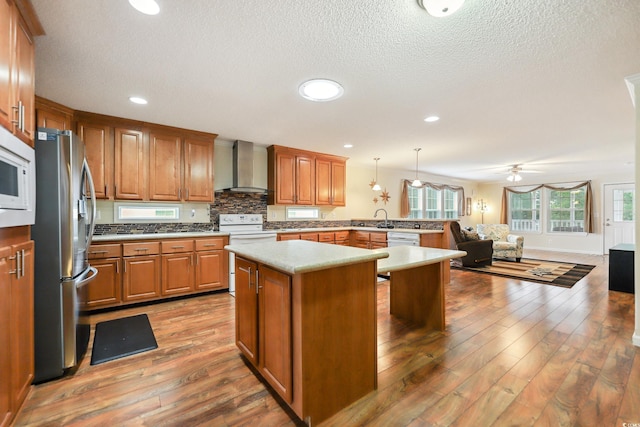 263 Walden Lake Rd, Conway, SC 29526 - kitchen featuring wall chimney exhaust hood, white appliances, plenty of natural light, a sink, and a textured ceiling