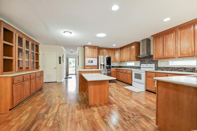 263 Walden Lake Rd, Conway, SC 29526 - kitchen featuring white appliances, wall chimney exhaust hood, a textured ceiling, light wood-style flooring, and tasteful backsplash