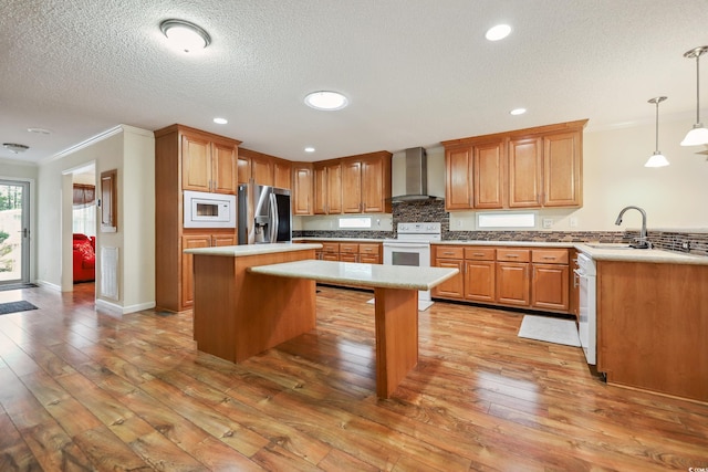 263 Walden Lake Rd, Conway, SC 29526 - kitchen featuring white appliances, wall chimney exhaust hood, crown molding, a peninsula, and a center island