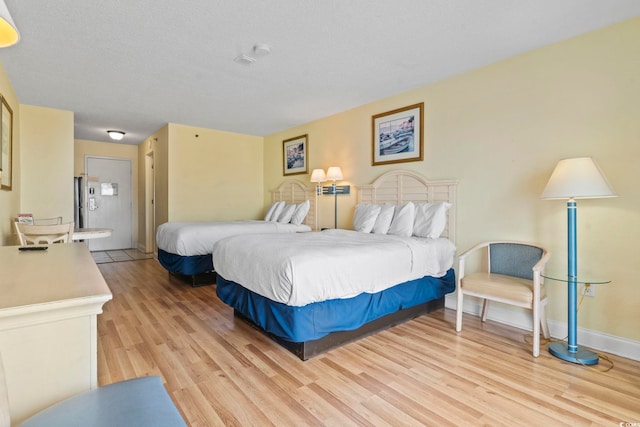 1207 S Ocean Blvd Unit 51001, Myrtle Beach, SC 29577 - bedroom with light wood finished floors, baseboards, and ensuite bath