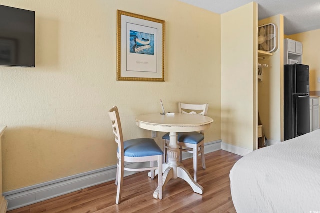 1207 S Ocean Blvd Unit 51001, Myrtle Beach, SC 29577 - bedroom featuring freestanding refrigerator, wood finished floors, and baseboards