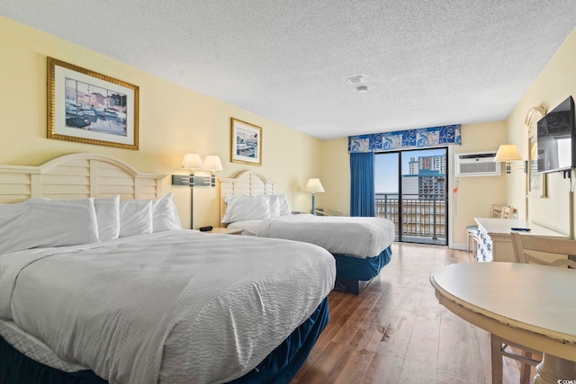 1207 S Ocean Blvd Unit 51001, Myrtle Beach, SC 29577 - bedroom with access to exterior, hardwood / wood-style floors, a textured ceiling, and a wall mounted air conditioner