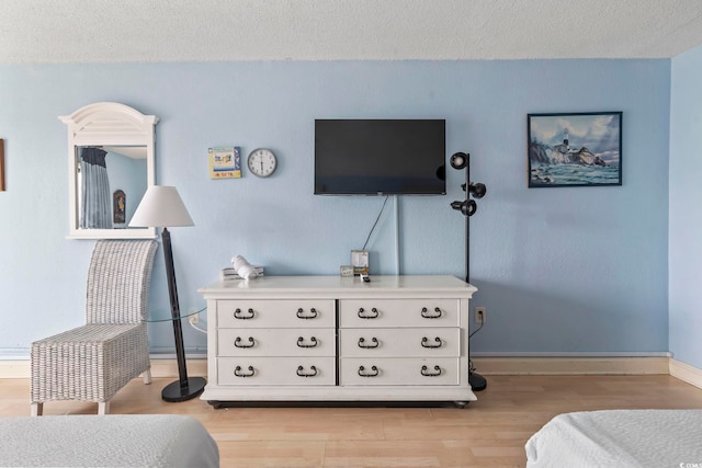 1207 S Ocean Blvd Unit 51312, Myrtle Beach, SC 29577 - bedroom with light wood finished floors, a textured ceiling, and baseboards