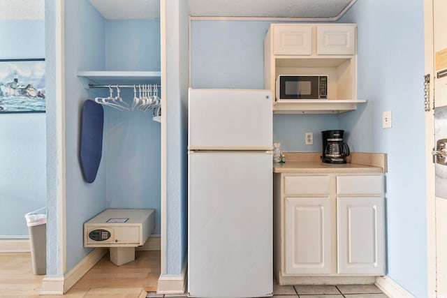 1207 S Ocean Blvd Unit 51312, Myrtle Beach, SC 29577 - kitchen featuring freestanding refrigerator, black microwave, light wood finished floors, open shelves, and light countertops