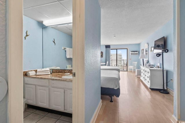 1207 S Ocean Blvd Unit 51312, Myrtle Beach, SC 29577 - bathroom featuring vanity, wood finished floors, baseboards, a wall mounted air conditioner, and connected bathroom