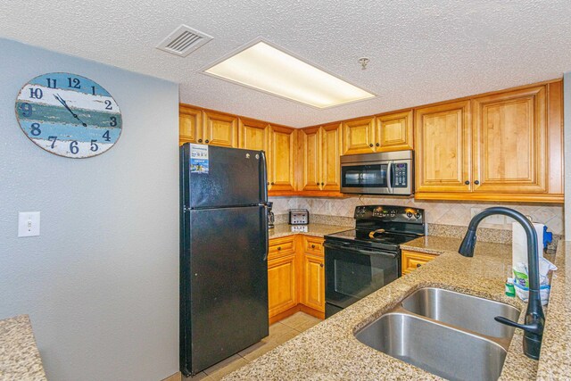 7100 N Ocean Blvd Unit 1421, Myrtle Beach, SC 29572 - kitchen featuring black appliances, a sink, backsplash, light tile patterned floors, and light stone counters