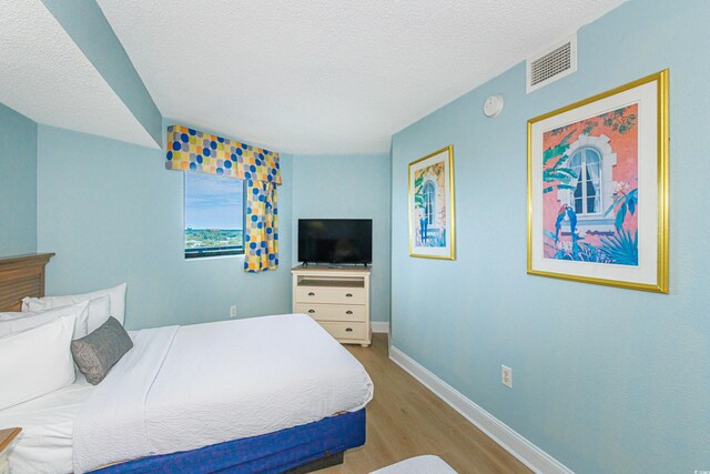 7100 N Ocean Blvd Unit 1421, Myrtle Beach, SC 29572 - bedroom with wood finished floors, baseboards, and a textured ceiling