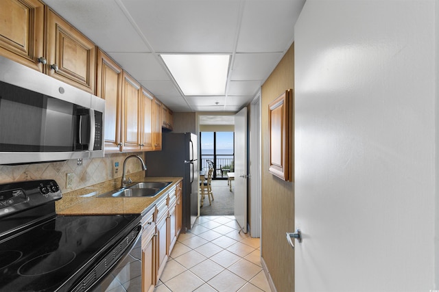 3000 N Ocean Blvd Unit 333, Myrtle Beach, SC 29577 - kitchen featuring black / electric stove, stainless steel microwave, a sink, light tile patterned floors, and baseboards