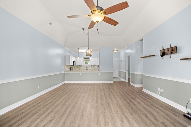 4767 Wild Iris Dr Unit 203, Myrtle Beach, SC 29579 - unfurnished living room featuring a ceiling fan, light wood-type flooring, high vaulted ceiling, baseboards, and a sink