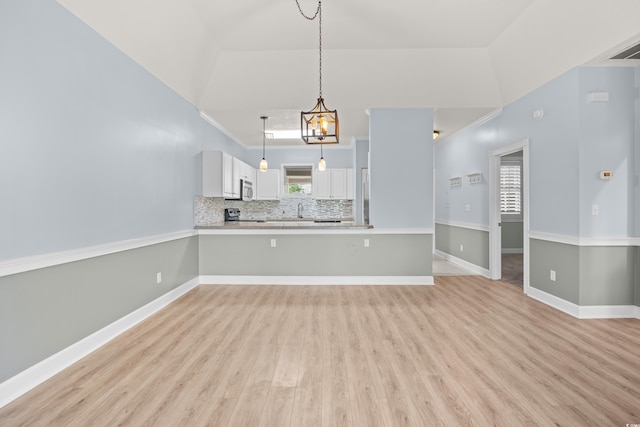 4767 Wild Iris Dr Unit 203, Myrtle Beach, SC 29579 - unfurnished living room featuring light wood-style flooring, a sink, baseboards, and lofted ceiling