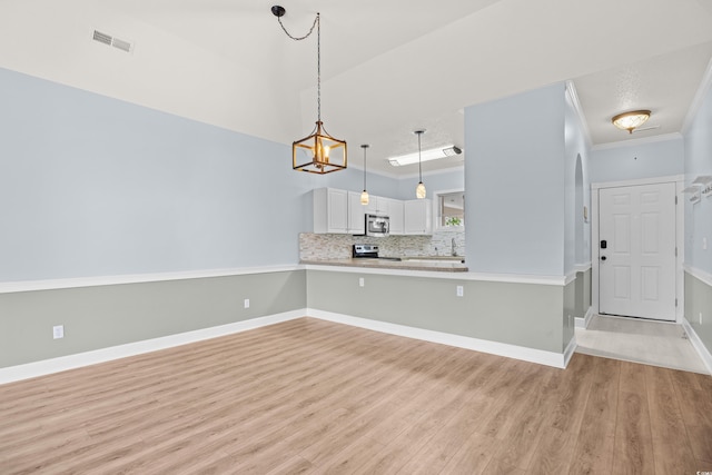 4767 Wild Iris Dr Unit 203, Myrtle Beach, SC 29579 - kitchen with stainless steel appliances, light wood finished floors, light countertops, white cabinetry, and crown molding