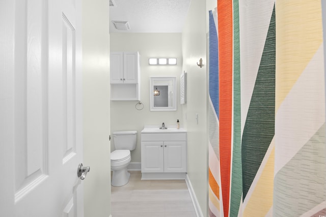 4767 Wild Iris Dr Unit 203, Myrtle Beach, SC 29579 - bathroom featuring toilet, vanity, baseboards, tile patterned floors, and a textured ceiling