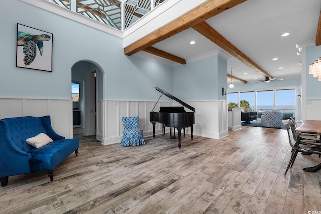 4900 N Ocean Blvd, Myrtle Beach, SC 29577 - living area with arched walkways, beam ceiling, wood finished floors, a wainscoted wall, and ceiling fan
