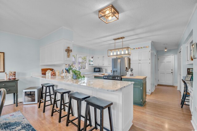 196 John Waites Ct, Georgetown, SC 29440 - kitchen featuring stainless steel fridge with ice dispenser, a peninsula, white cabinetry, light wood-type flooring, and a kitchen breakfast bar