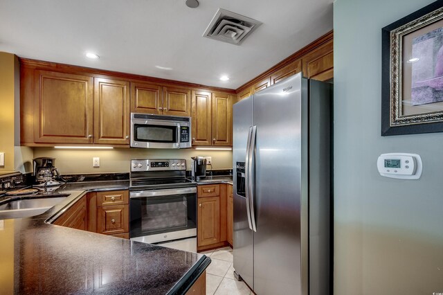 603 S Ocean Blvd Unit 1205, North Myrtle Beach, SC 29582 - kitchen with appliances with stainless steel finishes, dark countertops, a sink, brown cabinets, and recessed lighting
