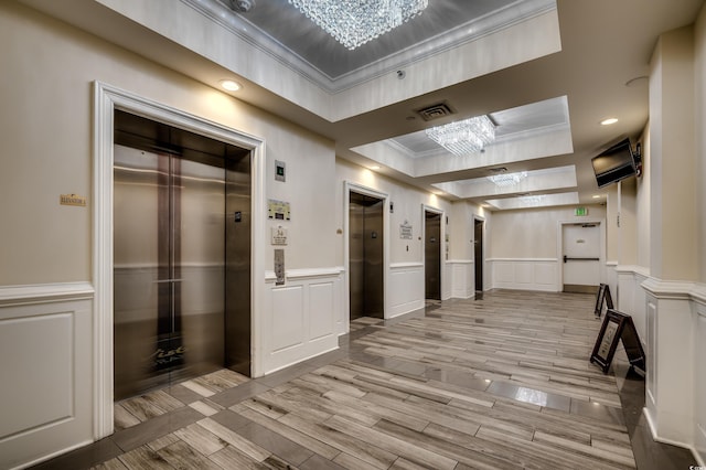 603 S Ocean Blvd Unit 1205, North Myrtle Beach, SC 29582 - hallway featuring a tray ceiling, elevator, a chandelier, a decorative wall, and ornamental molding