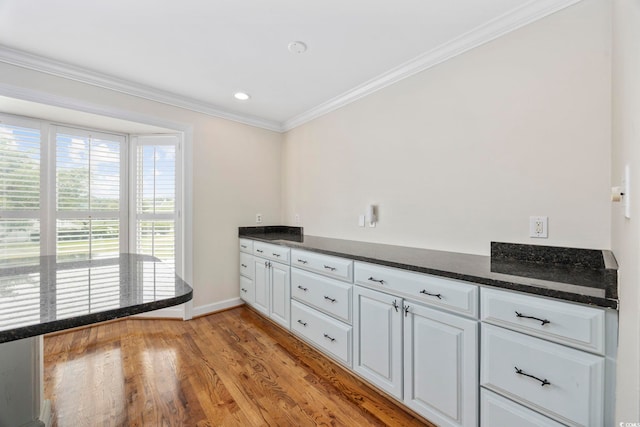465 Vereen Rd Unit 10, Murrells Inlet, SC 29576 - kitchen featuring crown molding, light wood finished floors, white cabinets, baseboards, and dark stone counters