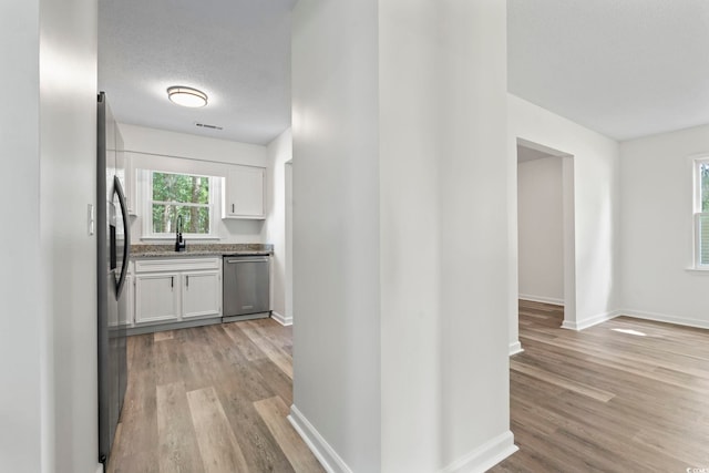 203 Deer Trce, Myrtle Beach, SC 29588 - kitchen with stainless steel appliances, light wood-style floors, white cabinetry, and light stone countertops