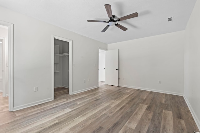 203 Deer Trce, Myrtle Beach, SC 29588 - unfurnished bedroom with wood finished floors, a walk in closet, a closet, baseboards, and ceiling fan