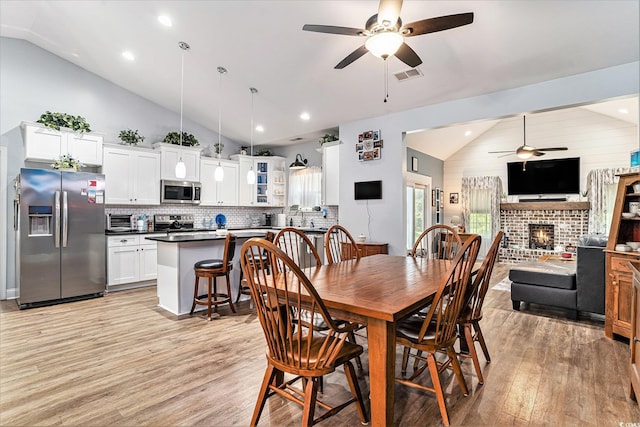 1904 Ronald Phillips Ave, Conway, SC 29527 - dining room featuring vaulted ceiling, a ceiling fan, light wood-style flooring, a brick fireplace, and recessed lighting