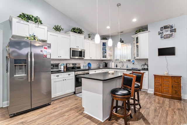 1904 Ronald Phillips Ave, Conway, SC 29527 - kitchen featuring stainless steel appliances, a sink, dark countertops, white cabinetry, and decorative backsplash