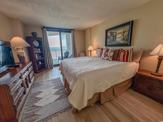 2101 S Ocean Blvd Unit A-4, North Myrtle Beach, SC 29582 - bedroom featuring access to outside, light wood-type flooring, and a textured ceiling