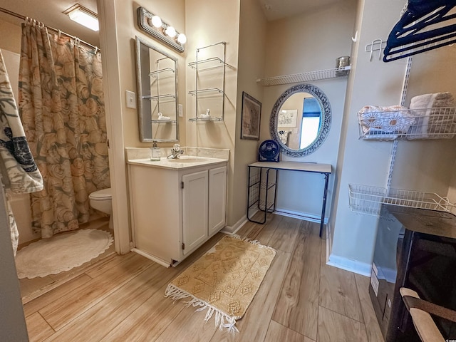 2101 S Ocean Blvd Unit A-4, North Myrtle Beach, SC 29582 - bathroom featuring wood finished floors, toilet, vanity, and baseboards