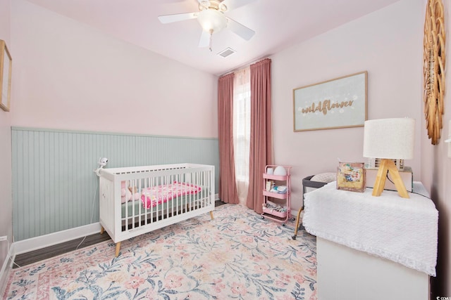 5149 Morning Frost Pl, Myrtle Beach, SC 29579 - bedroom featuring wainscoting, ceiling fan, baseboards, and a nursery area