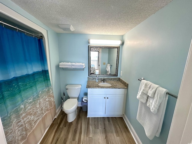 3000 N Ocean Blvd Unit 1406, Myrtle Beach, SC 29572 - bathroom featuring a textured ceiling, toilet, wood finished floors, vanity, and baseboards