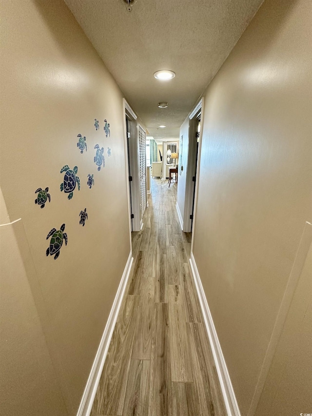 3000 N Ocean Blvd Unit 1406, Myrtle Beach, SC 29572 - hallway featuring light wood-type flooring, baseboards, and a textured ceiling