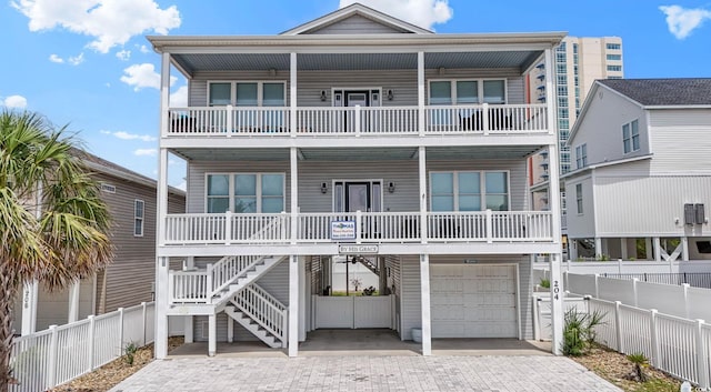 204 33rd Ave N, North Myrtle Beach, SC 29582 - coastal home with a balcony, a porch, an attached garage, driveway, and stairway