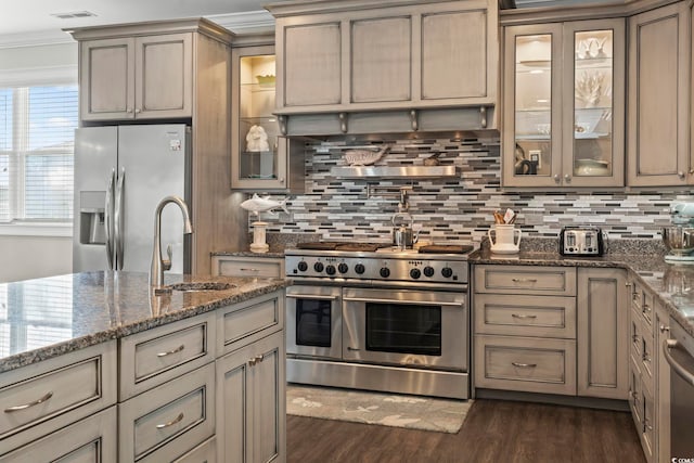 204 33rd Ave N, North Myrtle Beach, SC 29582 - kitchen featuring appliances with stainless steel finishes, dark wood-style flooring, decorative backsplash, a sink, and stone counters