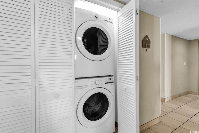 2511 S Ocean Blvd Unit 507G, Myrtle Beach, SC 29577 - laundry room with stacked washing machine and dryer, light tile patterned flooring, baseboards, and a textured ceiling