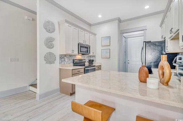 3477 Bristol Ln Unit 3477, Myrtle Beach, SC 29577 - kitchen with appliances with stainless steel finishes, a peninsula, tasteful backsplash, light wood finished floors, and light stone countertops