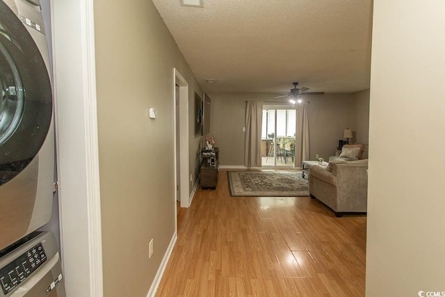 6610 Mallard View Pt, Myrtle Beach, SC 29588 - hall featuring stacked washer / drying machine, light wood-type flooring, a textured ceiling, and baseboards