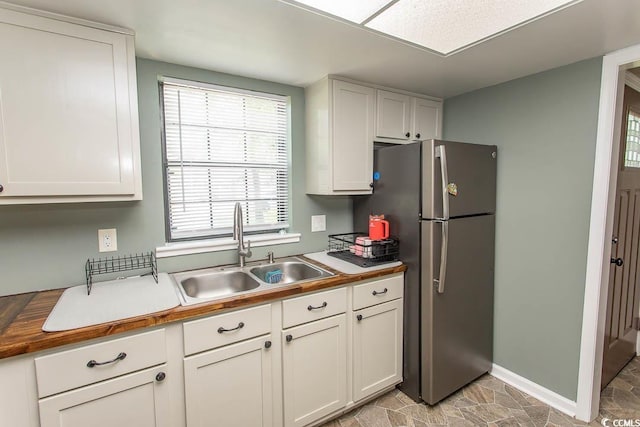 6610 Mallard View Pt, Myrtle Beach, SC 29588 - kitchen featuring a sink, healthy amount of natural light, freestanding refrigerator, and white cabinetry