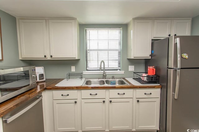 6610 Mallard View Pt, Myrtle Beach, SC 29588 - kitchen with stainless steel appliances, a sink, wooden counters, and white cabinetry